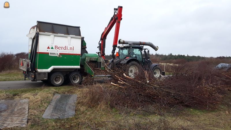 Valtra met Kraan ingevoerde takken versnipperaar