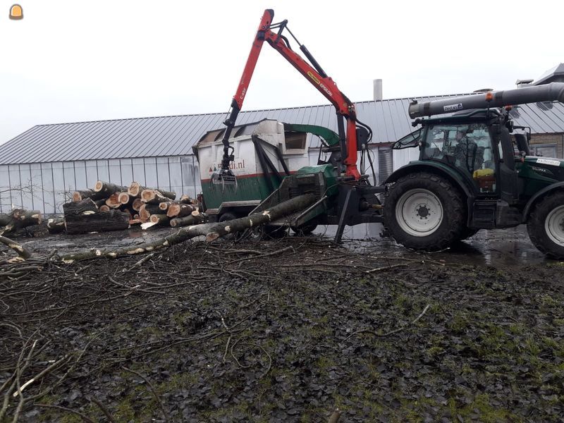 Valtra met Kraan ingevoerde takken versnipperaar