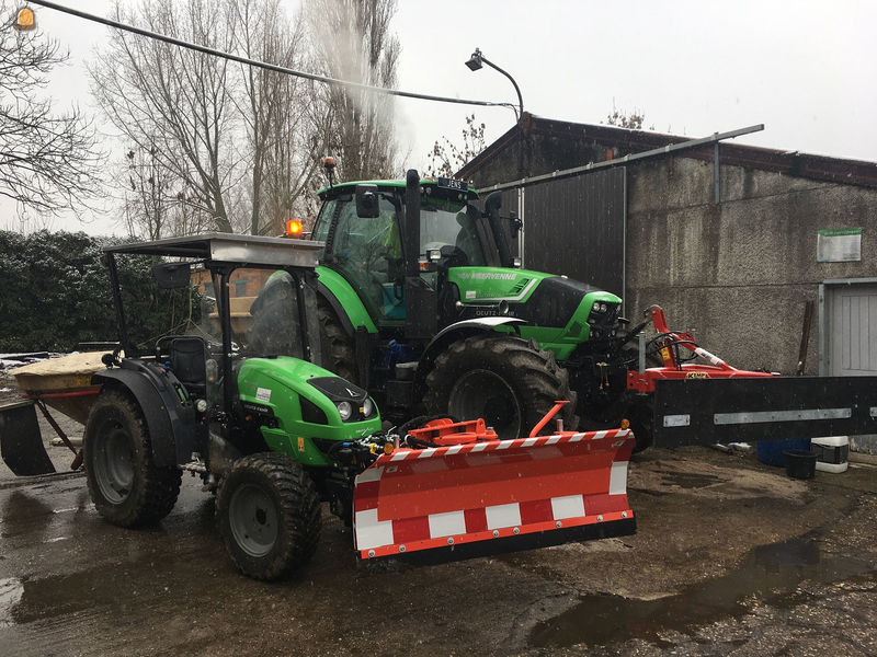 Winterdienst met tractor met  sneeuwschuif en zoutstrooier