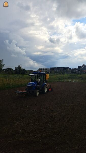 New Holland boomer met rotorkopeg en zaaimachine